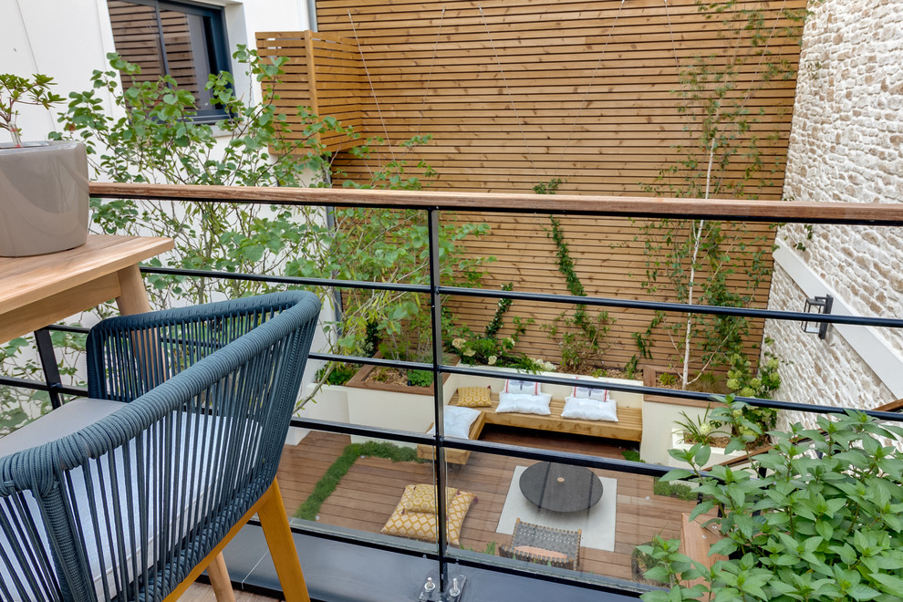 Réalisation d'une terrasse design avec une cuisine d'été, une cour et une extension de toiture.
