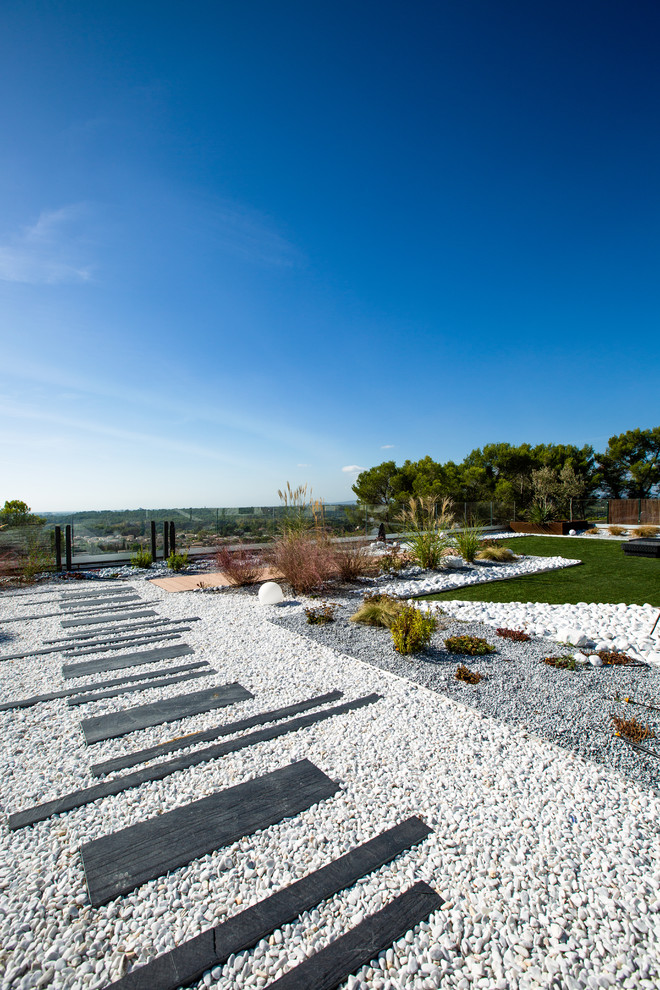 Großer Moderner Patio mit Kies mit Kübelpflanzen in Montpellier
