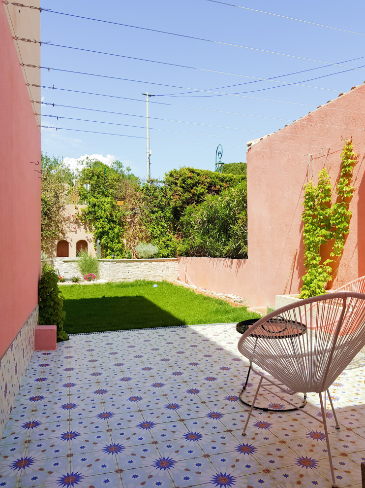 Foto de patio mediterráneo de tamaño medio en patio trasero con suelo de baldosas y pérgola