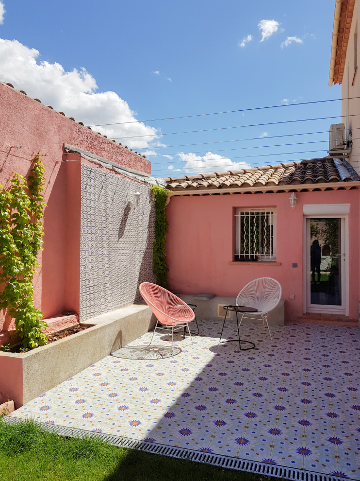 Foto de patio mediterráneo de tamaño medio en patio trasero con suelo de baldosas y pérgola