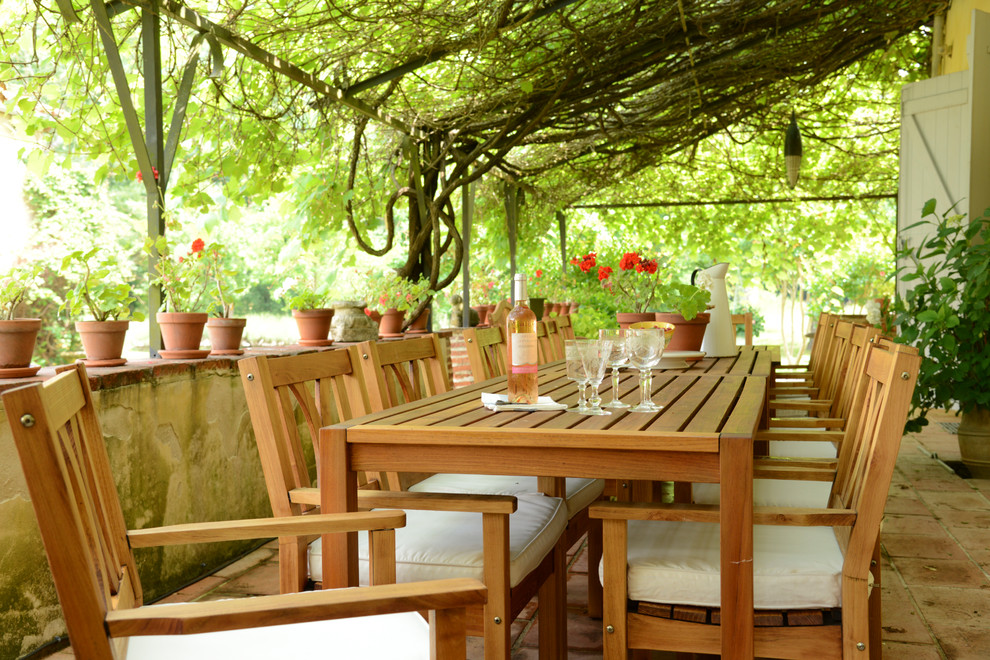 Foto de patio mediterráneo de tamaño medio con adoquines de ladrillo y pérgola