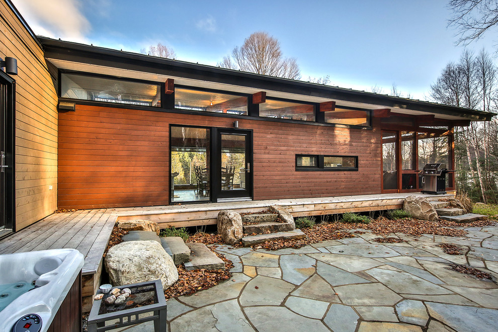 Imagen de patio contemporáneo de tamaño medio en patio trasero y anexo de casas con adoquines de piedra natural