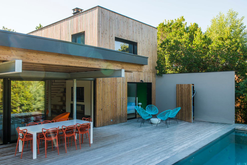 Diseño de terraza contemporánea de tamaño medio en patio trasero y anexo de casas