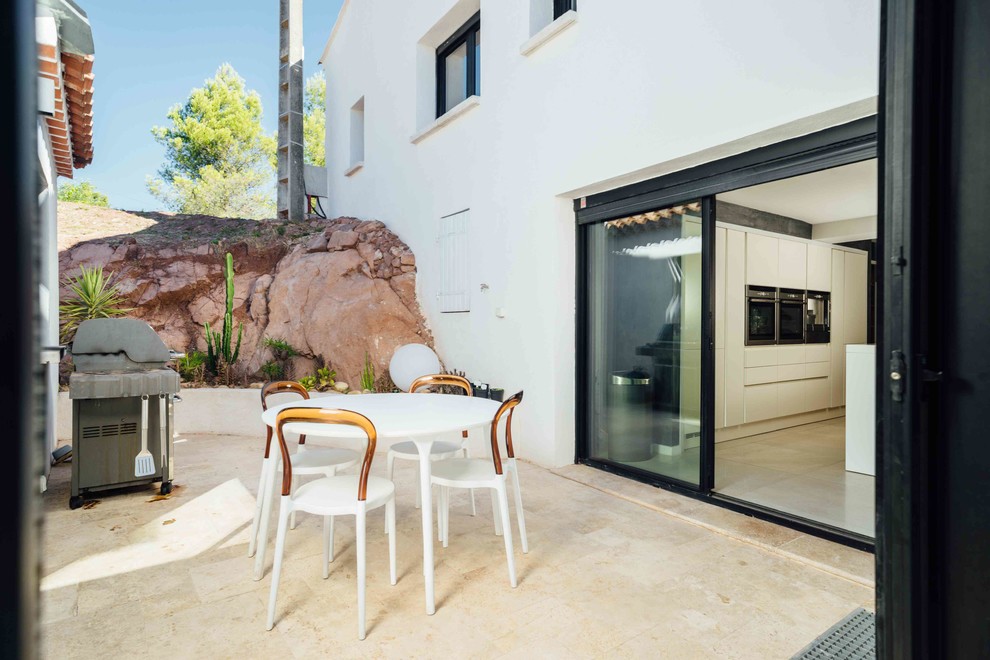 Cette image montre une petite terrasse méditerranéenne avec une cuisine d'été, une cour, une dalle de béton et aucune couverture.