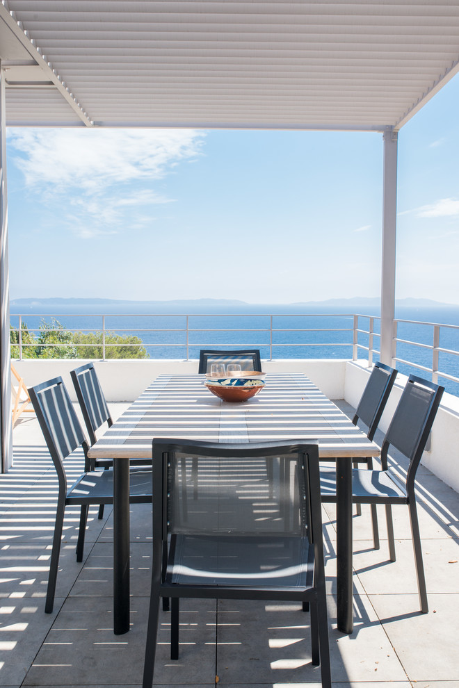 Aménagement d'une terrasse latérale contemporaine de taille moyenne avec une cuisine d'été, du carrelage et une pergola.