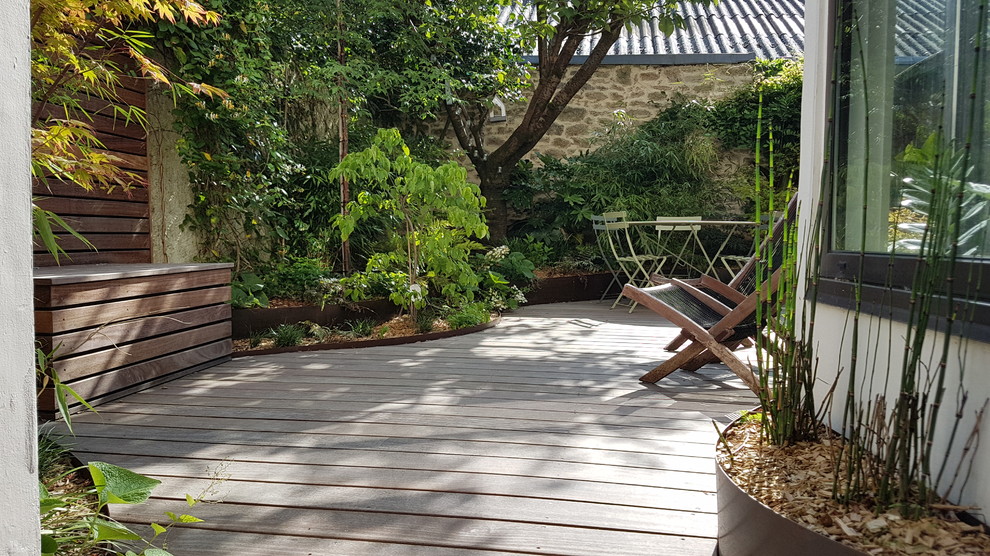 Imagen de patio tropical de tamaño medio sin cubierta en patio con jardín de macetas y entablado