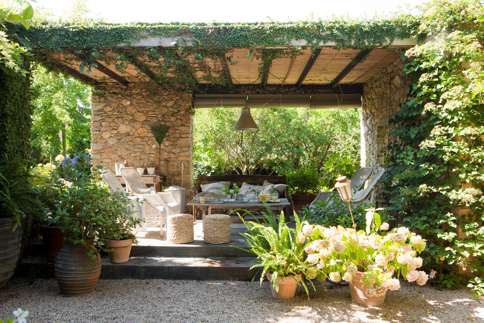Immagine di un grande patio o portico country con un giardino in vaso e un gazebo o capanno