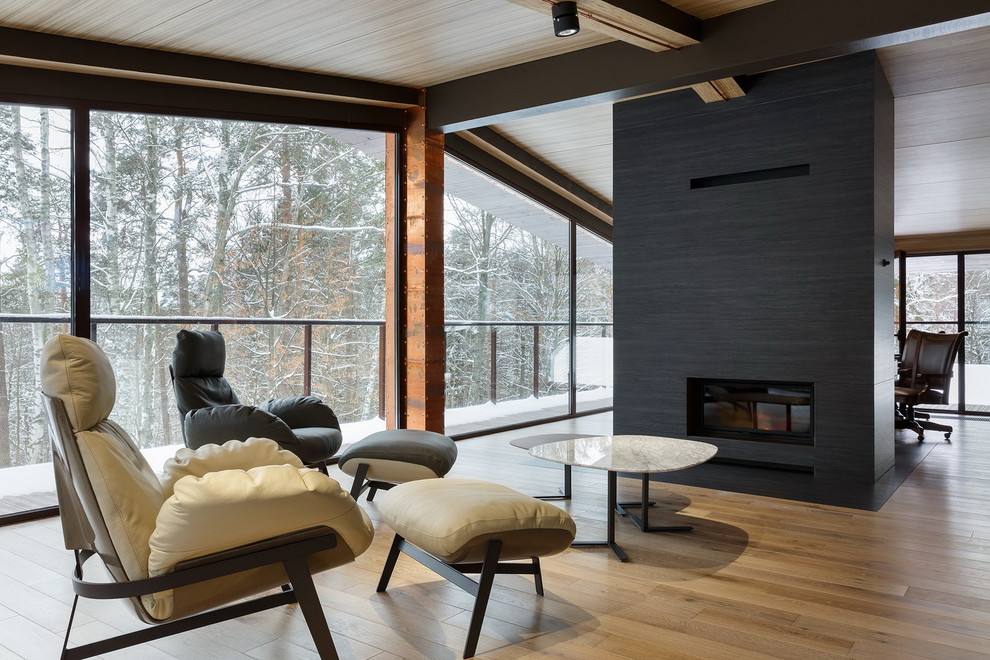 Idée de décoration pour une véranda design avec un sol en bois brun, une cheminée standard, un plafond standard et un sol beige.