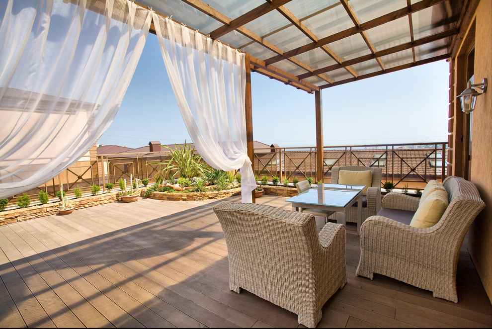 Modelo de terraza mediterránea grande en azotea con jardín de macetas y toldo