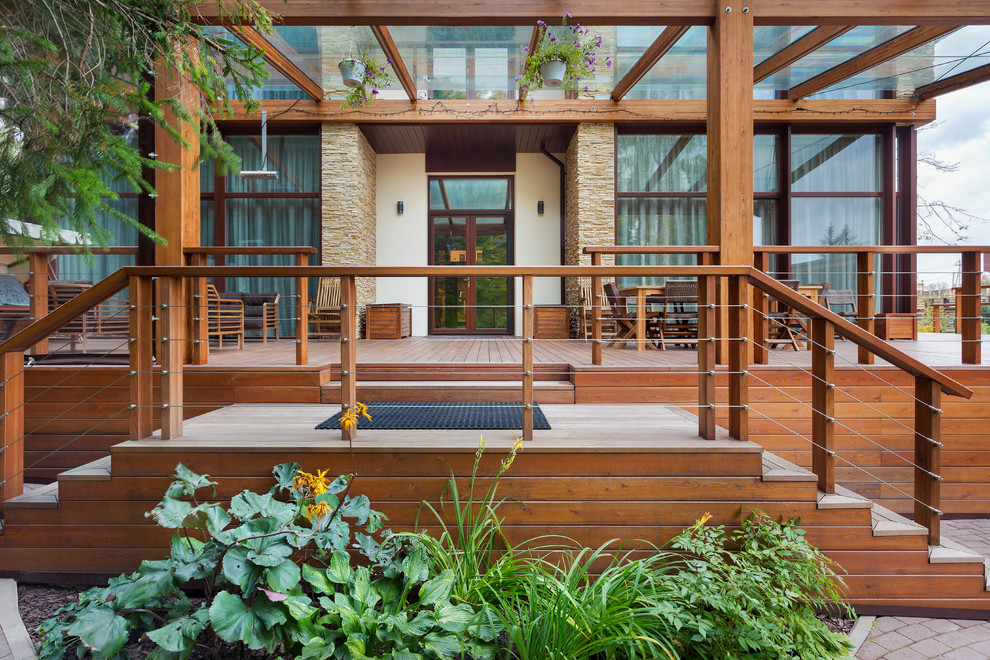 Ejemplo de terraza planta baja mediterránea grande en anexo de casas y patio con cocina exterior y barandilla de madera