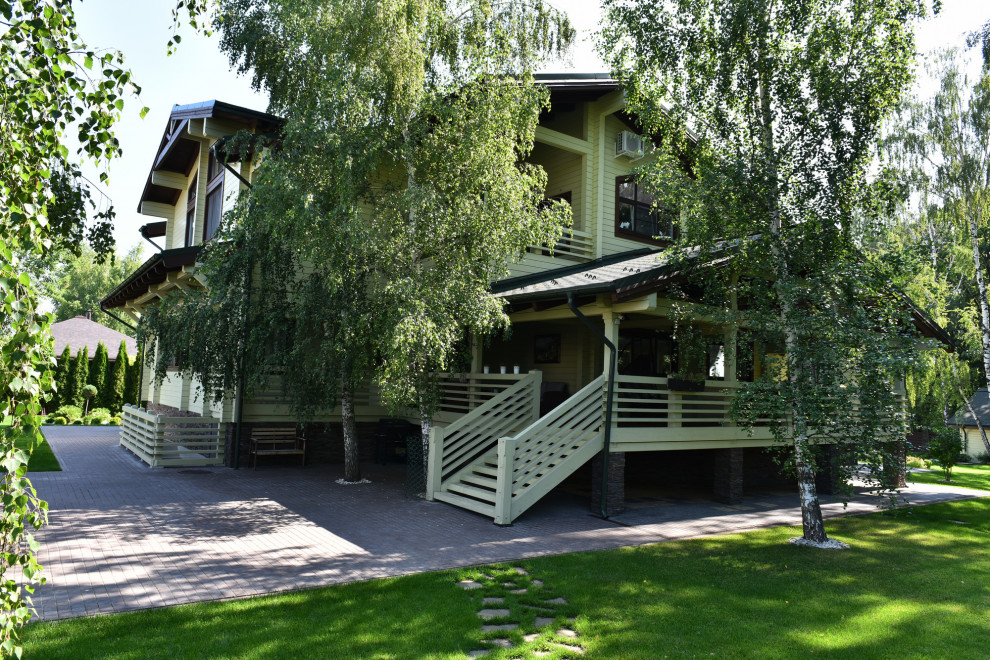 Ejemplo de terraza planta baja de estilo de casa de campo de tamaño medio en patio y anexo de casas con barandilla de madera