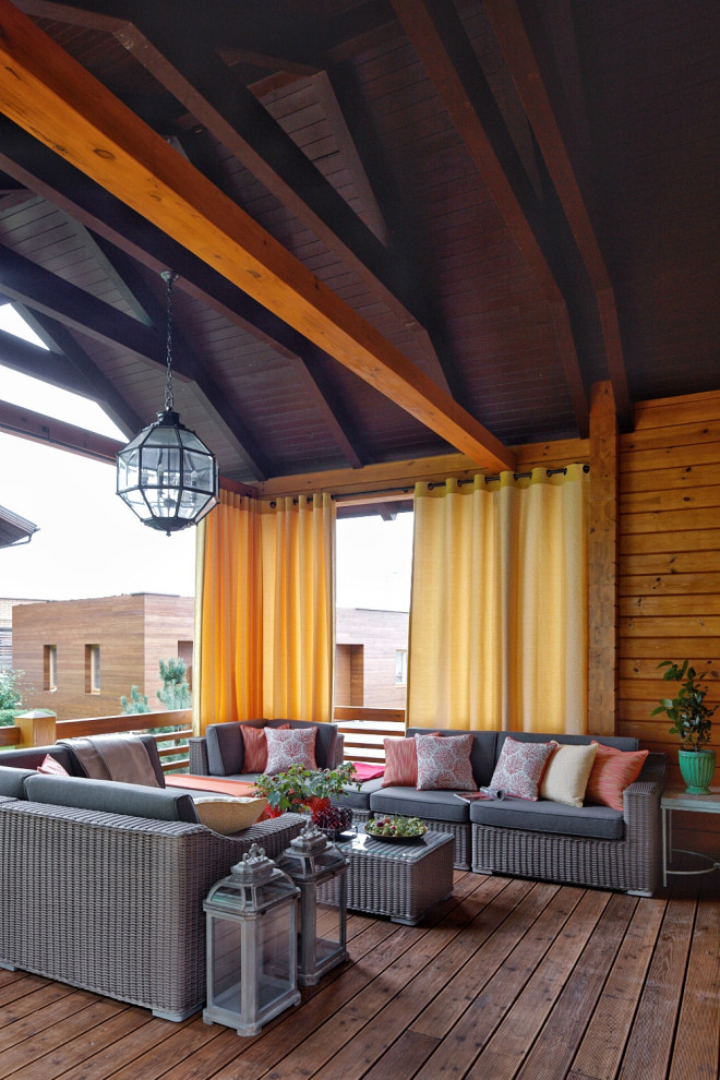 Imagen de terraza planta baja de estilo de casa de campo de tamaño medio en patio y anexo de casas con barandilla de madera