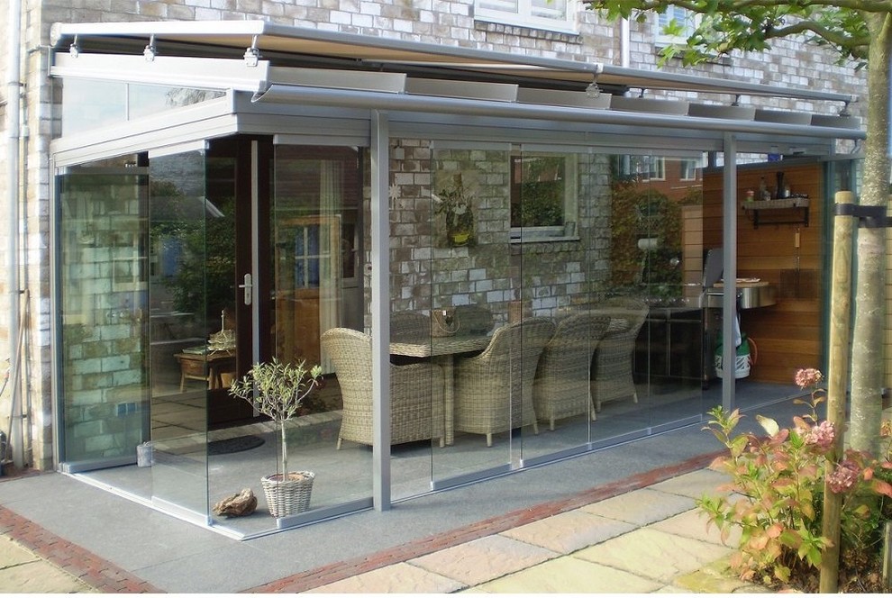 Immagine di una veranda design di medie dimensioni con soffitto in vetro e pavimento bianco