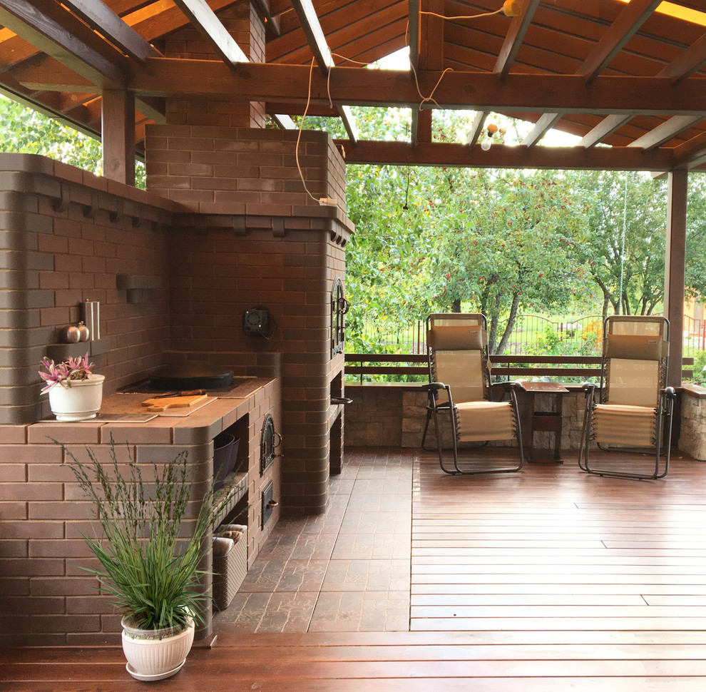 На фото: пергола на террасе среднего размера на боковом дворе в современном стиле с летней кухней