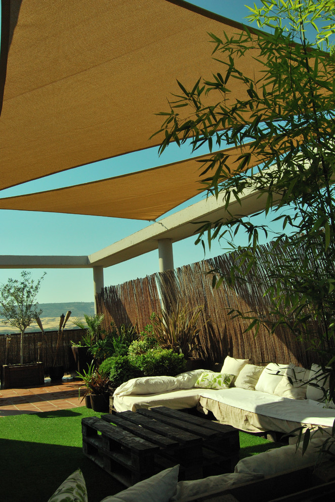 Стильный дизайн: маленькая терраса на крыше в восточном стиле с растениями в контейнерах и козырьком для на участке и в саду - последний тренд