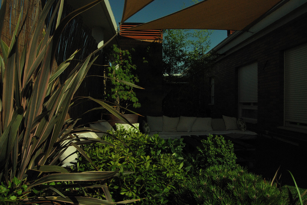 Kleine Asiatische Dachterrasse mit Kübelpflanzen und Markisen in Madrid