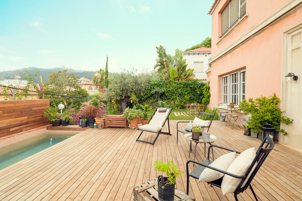 Modelo de terraza mediterránea sin cubierta en patio trasero con jardín de macetas