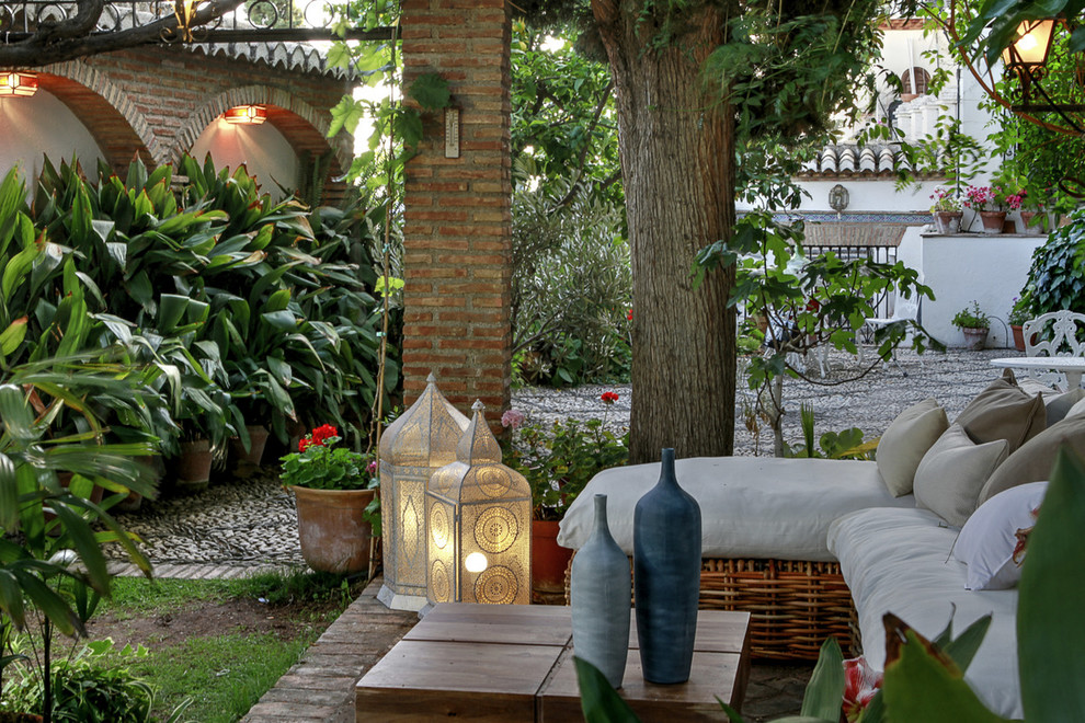 Réalisation d'un porche avec des plantes en pot méditerranéen avec des pavés en pierre naturelle et une pergola.