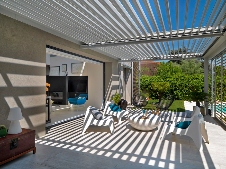 Photo of a large contemporary front veranda in Madrid with tiled flooring and a pergola.