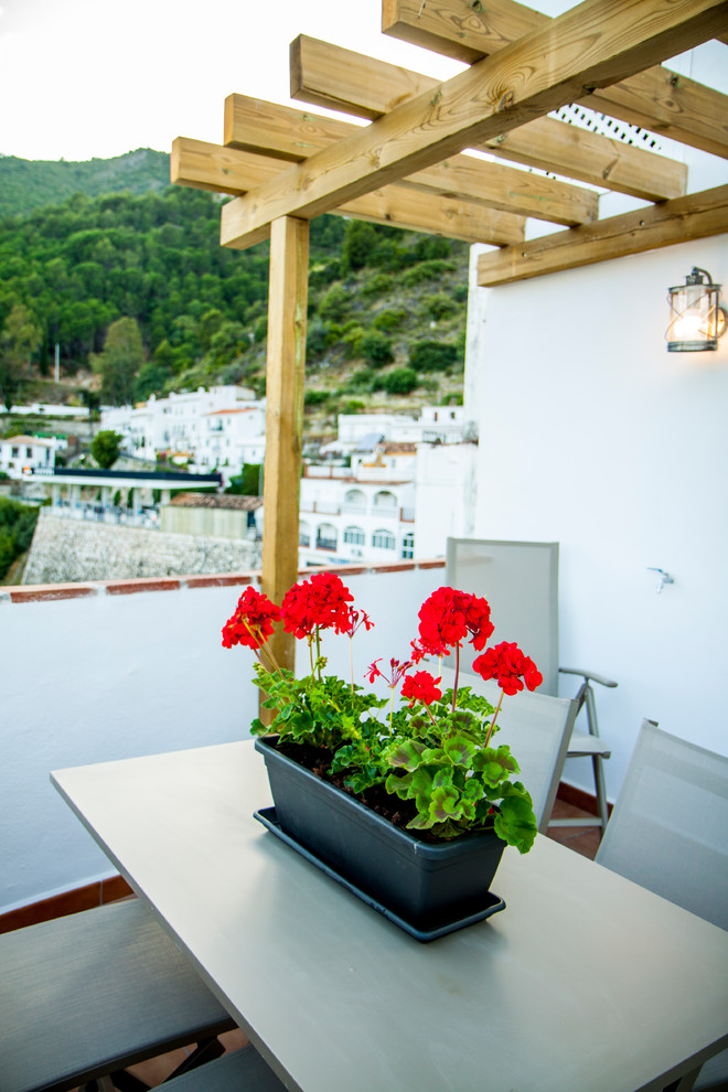 Inspiration for a small mediterranean roof terrace in Malaga with a pergola.