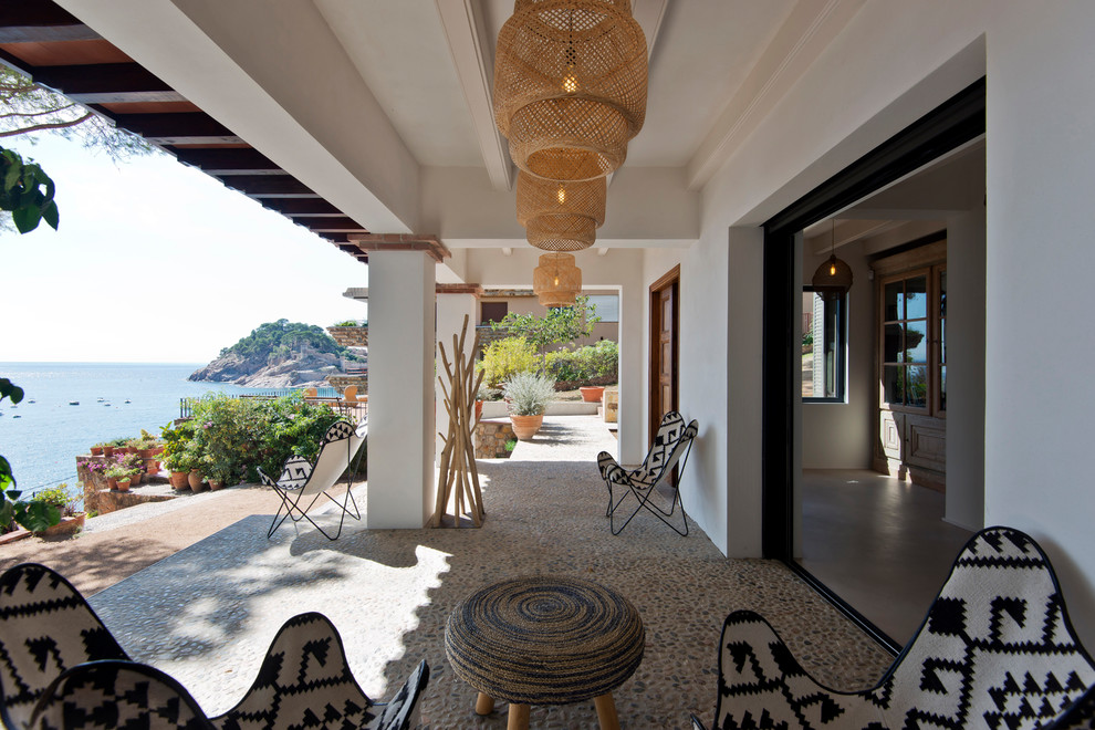 Réalisation d'un grand porche d'entrée de maison arrière méditerranéen avec une extension de toiture.
