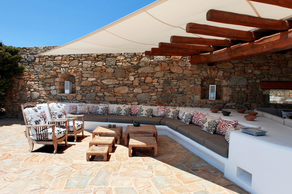 Diseño de patio mediterráneo grande en patio trasero con toldo