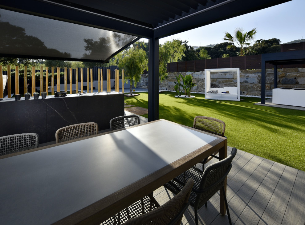 Exemple d'une terrasse méditerranéenne de taille moyenne avec une cuisine d'été, une cour et une pergola.