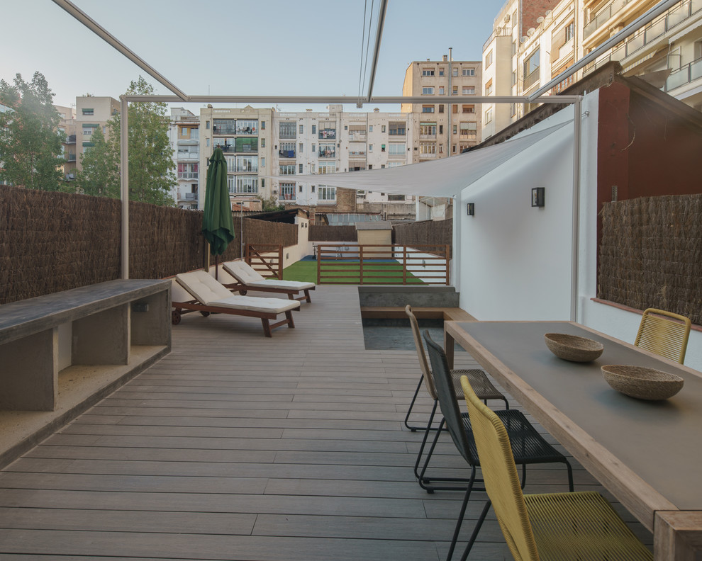 Imagen de terraza moderna grande en patio trasero con toldo