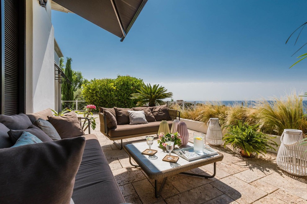 Modelo de terraza mediterránea grande en azotea con jardín de macetas y toldo