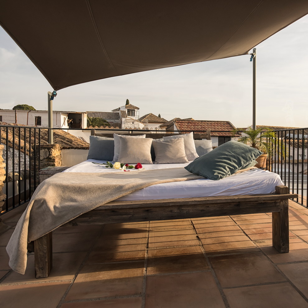 Ispirazione per una terrazza mediterranea di medie dimensioni, sul tetto e sul tetto con un parasole