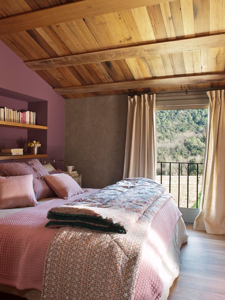 Ejemplo de dormitorio principal rural de tamaño medio sin chimenea con paredes multicolor y suelo de madera en tonos medios