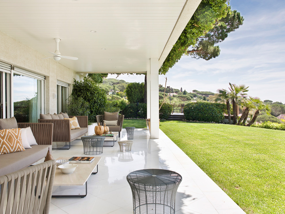 Стильный дизайн: веранда на заднем дворе в средиземноморском стиле с покрытием из плитки и навесом - последний тренд