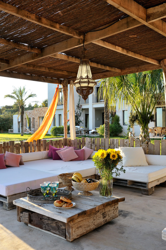 Inspiration for a medium sized mediterranean front veranda in Other with concrete slabs and feature lighting.