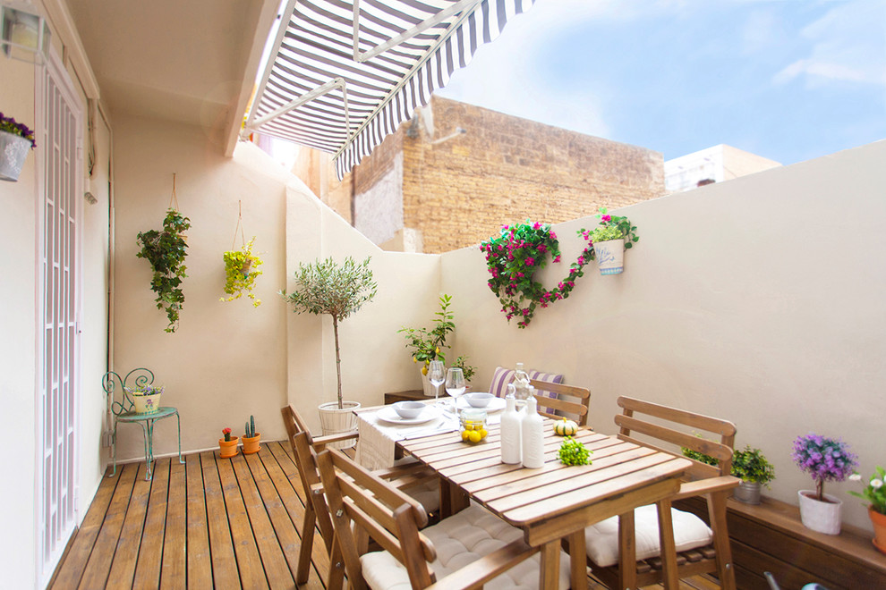 Diseño de terraza mediterránea de tamaño medio con jardín de macetas y toldo
