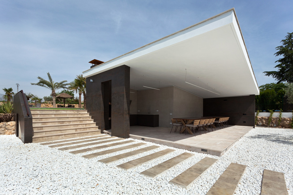 Modelo de terraza minimalista grande en anexo de casas con cocina exterior y suelo de baldosas