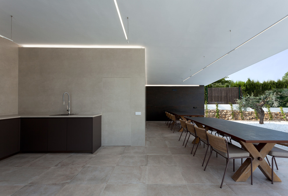 Diseño de terraza minimalista en anexo de casas con cocina exterior y suelo de baldosas