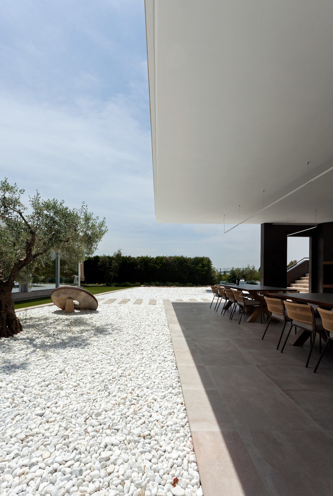 Imagen de terraza moderna en anexo de casas con cocina exterior y suelo de baldosas
