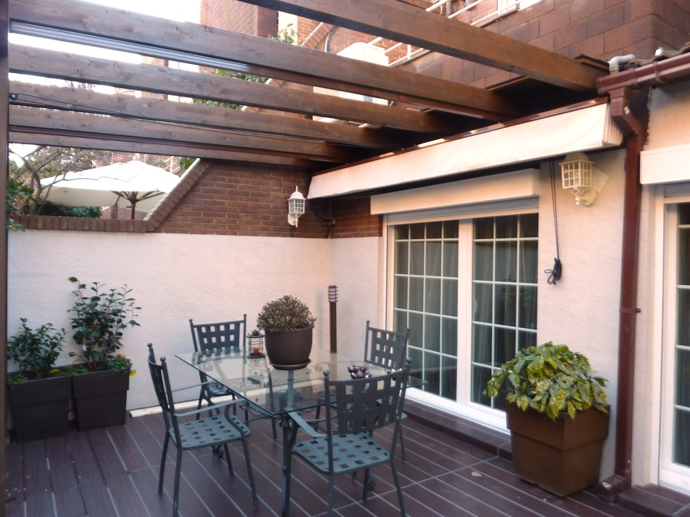 Foto de terraza actual de tamaño medio en patio trasero con pérgola
