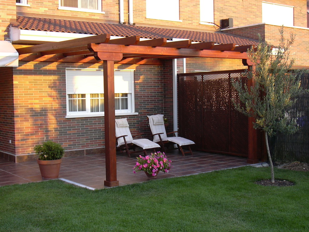 Ejemplo de terraza contemporánea de tamaño medio en patio trasero con pérgola