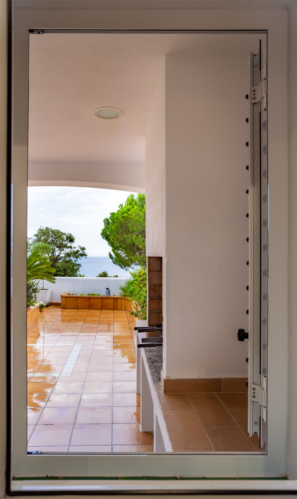 Cette image montre un porche d'entrée de maison arrière méditerranéen de taille moyenne avec une cheminée.