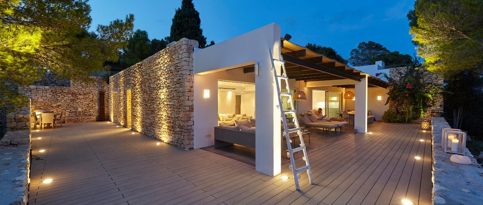Ispirazione per una terrazza mediterranea dietro casa con un tetto a sbalzo e con illuminazione