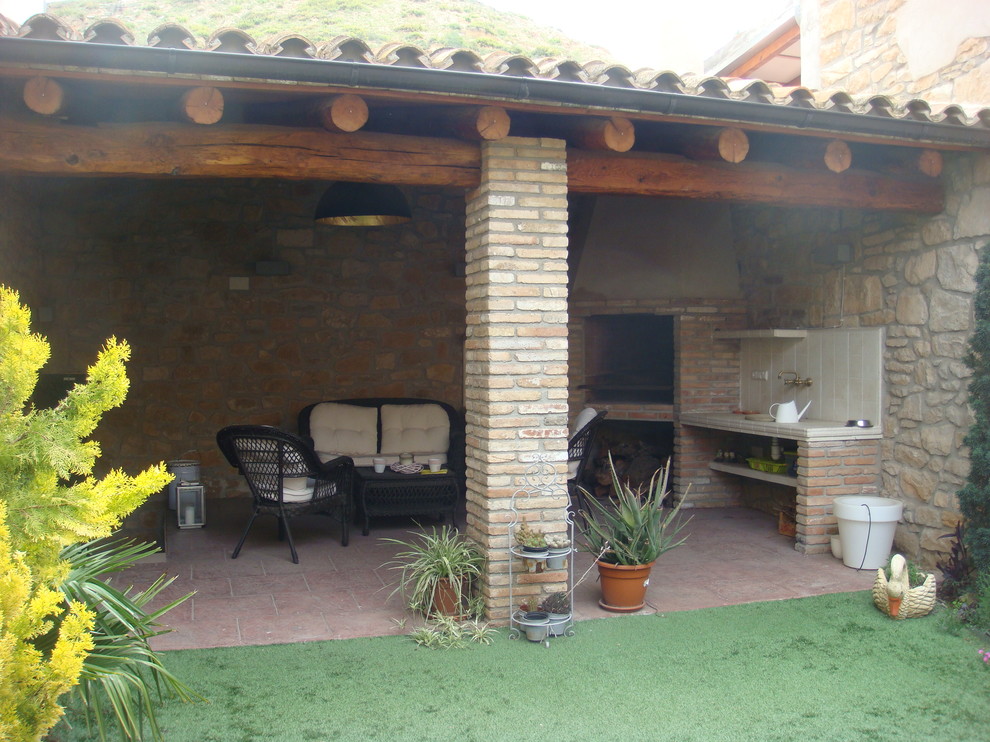 Cette image montre un porche d'entrée de maison latéral méditerranéen avec un foyer extérieur, du carrelage et une extension de toiture.