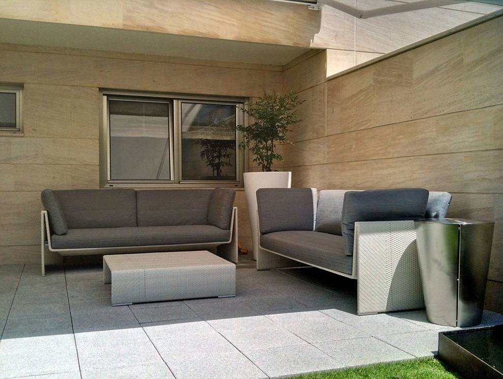 Design ideas for a medium sized contemporary back patio in Madrid with an awning.