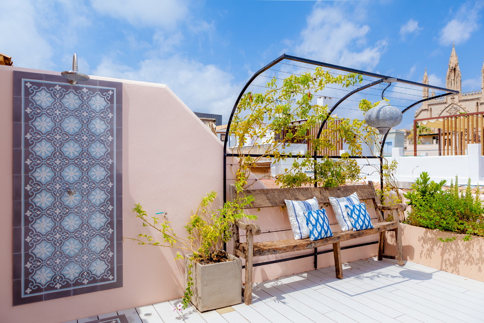 他の地域にあるお手頃価格の中くらいな地中海スタイルのおしゃれな屋上のデッキ (屋外シャワー、日よけなし、屋上) の写真