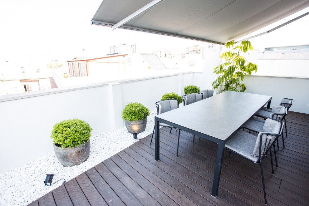 Foto de terraza actual en azotea con jardín de macetas y toldo