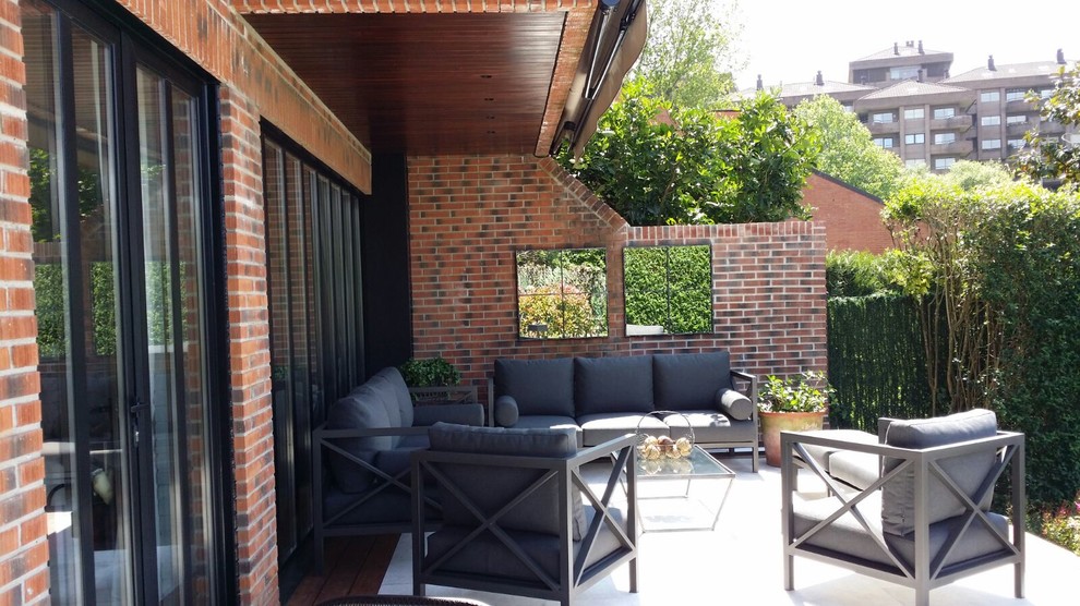 Diseño de terraza tradicional renovada de tamaño medio en patio trasero con toldo