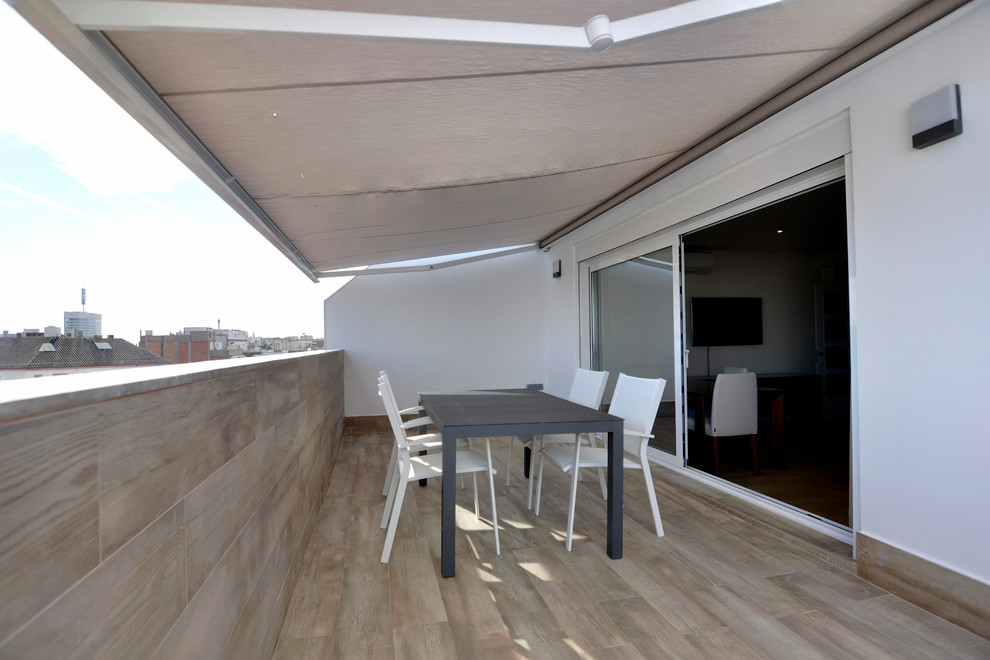 This is an example of a medium sized contemporary side terrace in Barcelona with an awning.