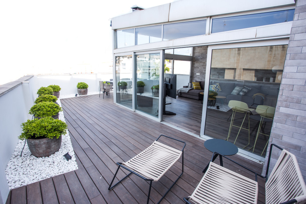 Imagen de terraza contemporánea con jardín vertical y toldo