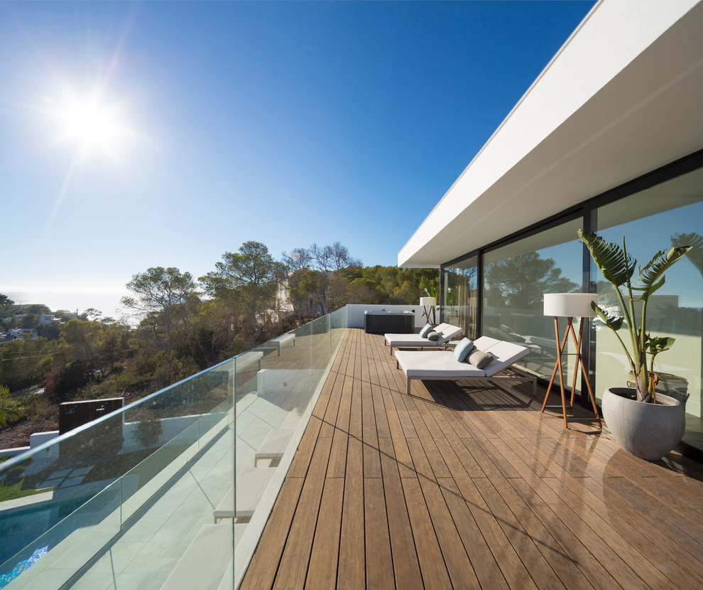 Inspiration pour une grande terrasse design avec une extension de toiture.