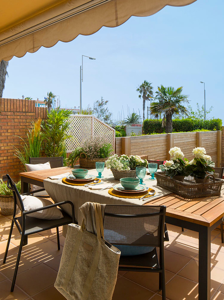 This is an example of a large scandi back terrace in Other with a potted garden and an awning.